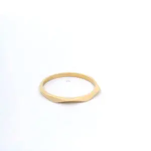 Thin faceted gold ring on white background
