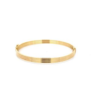 Gold ribbed bangle bracelet on white background