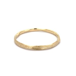 Textured gold bangle on white background
