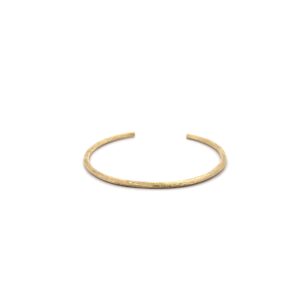 Gold textured open cuff bracelet on white