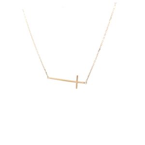 delicate gold sideways cross necklace on white