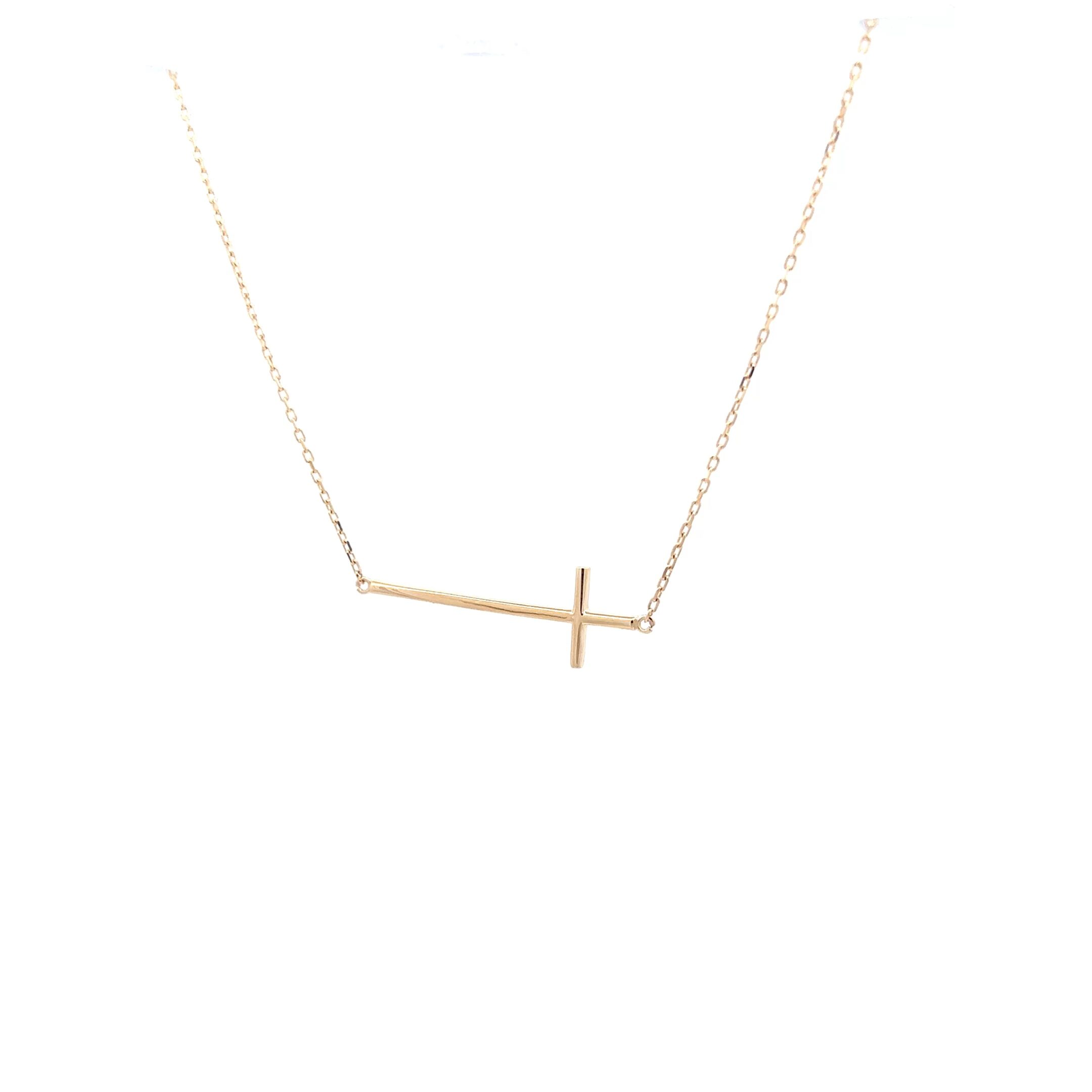 delicate gold sideways cross necklace on white